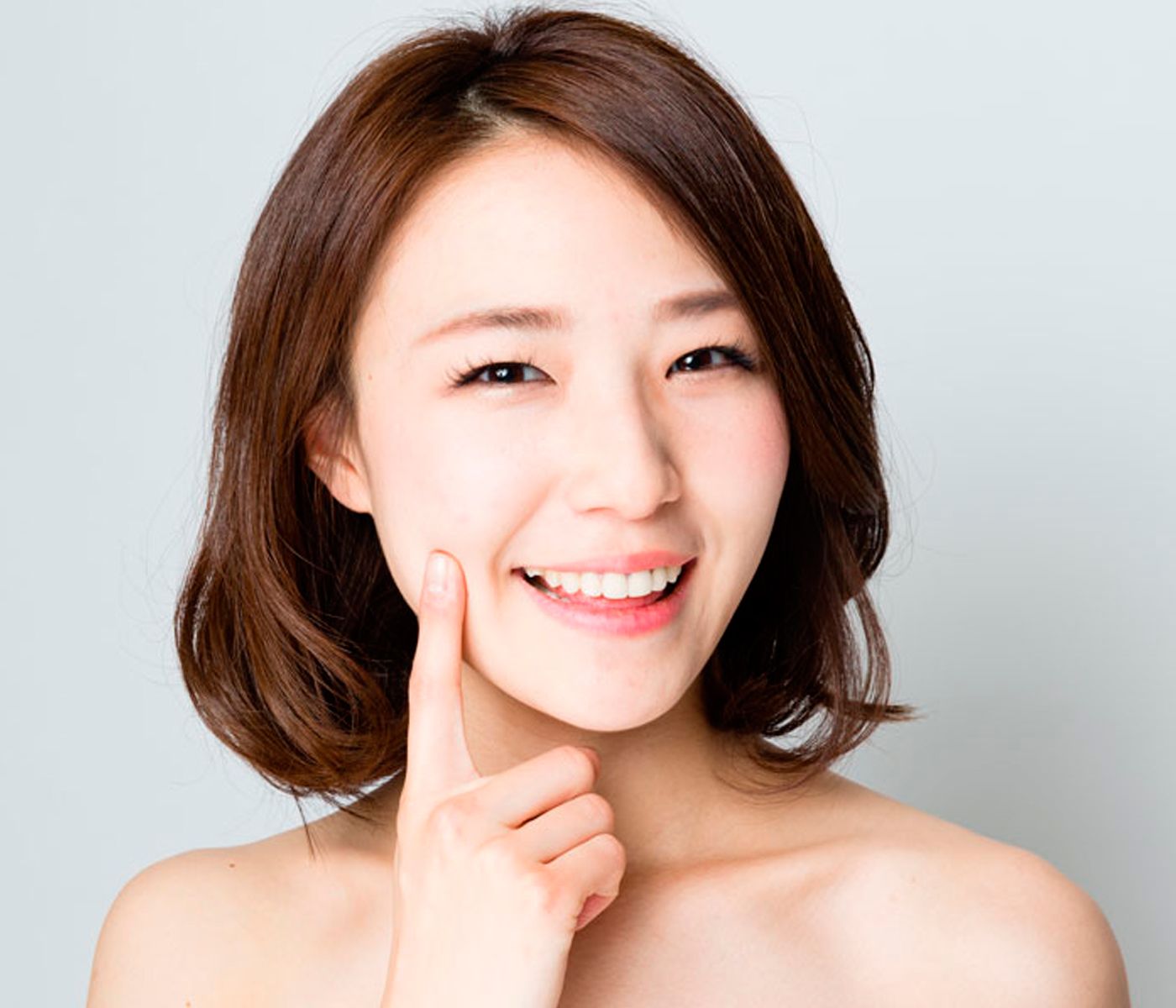 A happy Asian woman after rhinoplasty